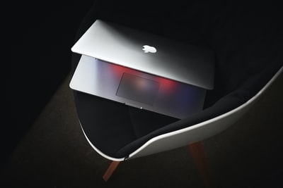 黑色软垫椅上的MacBook Pro